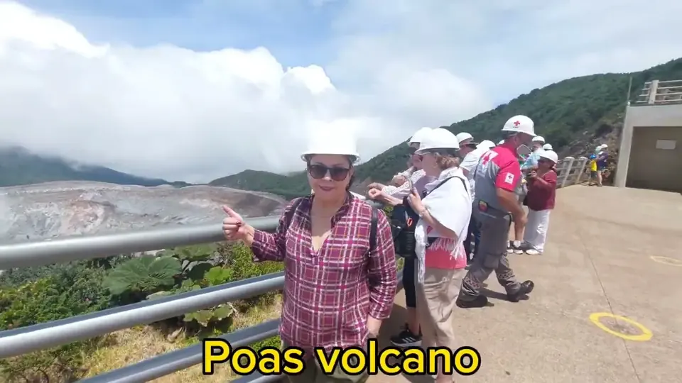 Travelers in hard hats at the Poás Volcano crater lookout