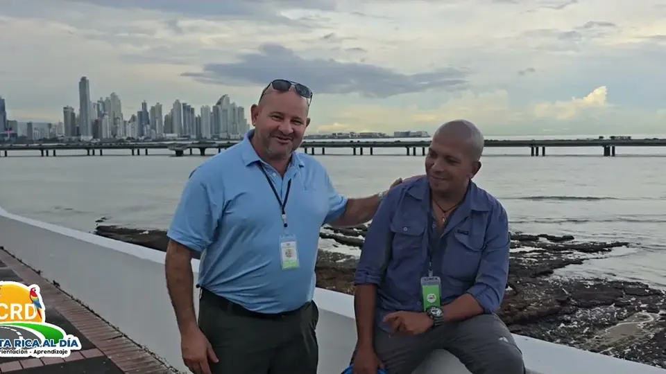 Two community members on the waterfront with the Panama City skyline behind them