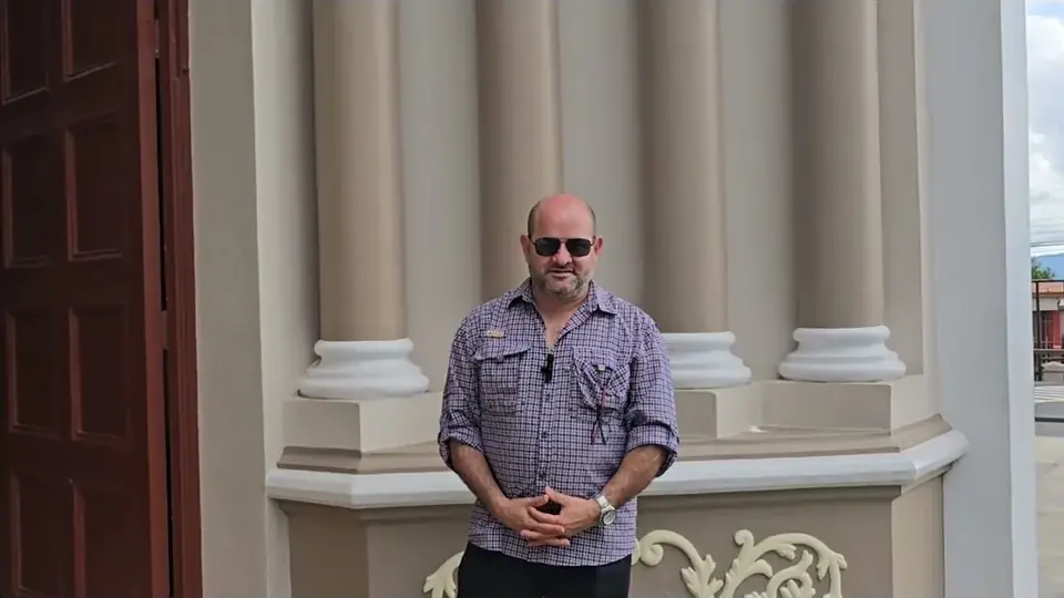 Oscar Calvo in front of a church in a Costa Rican town